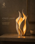 Lámpara Ignis beige con forma de llama esculpida emitiendo un resplandor cálido