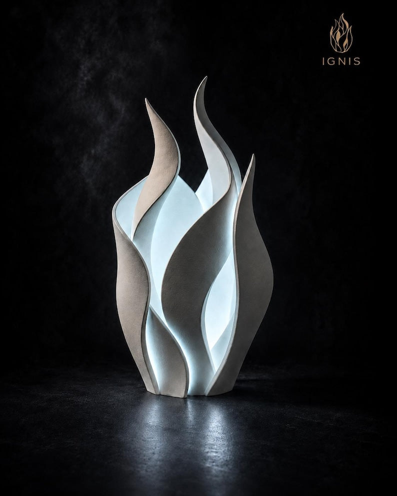 Lámpara Ignis con exterior beige mate e interior iluminado sobre fondo oscuro